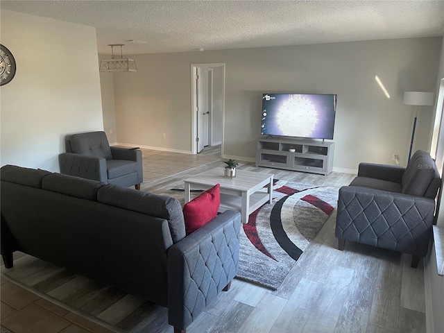 living room with a textured ceiling and light wood-type flooring