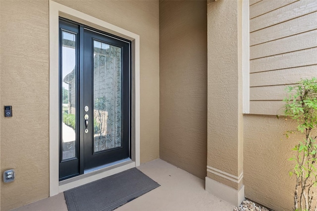 property entrance with stucco siding