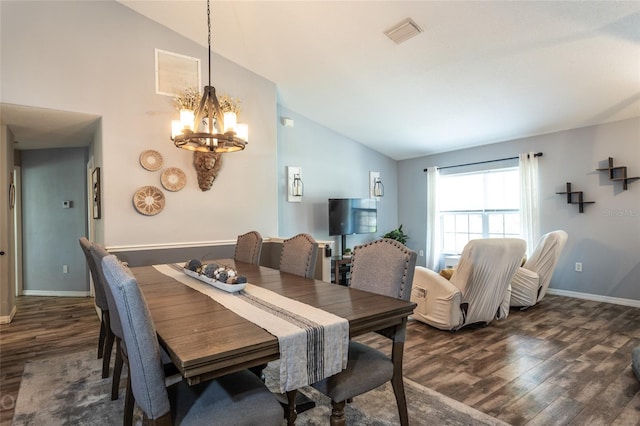 dining space featuring dark hardwood / wood-style flooring, high vaulted ceiling, and an inviting chandelier