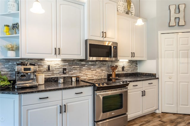 kitchen featuring white cabinetry, appliances with stainless steel finishes, pendant lighting, and decorative backsplash