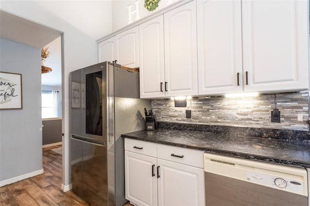 kitchen with dishwashing machine, backsplash, white cabinetry, and stainless steel fridge