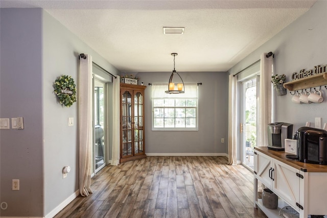 dining area with wood-type flooring and a textured ceiling