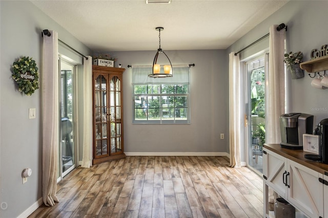 dining space with light hardwood / wood-style flooring and plenty of natural light