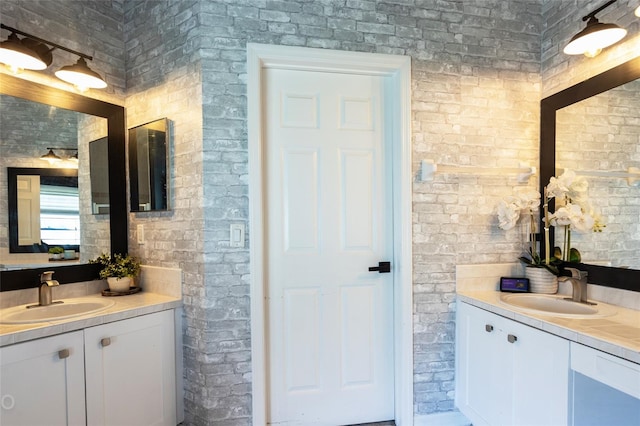 bathroom with vanity and brick wall