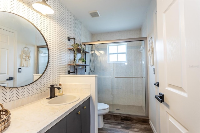 bathroom featuring wood-type flooring, decorative backsplash, vanity, walk in shower, and toilet