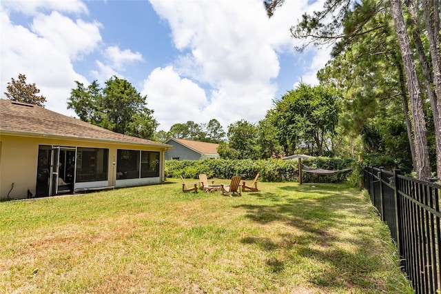 view of yard with a sunroom and an outdoor fire pit