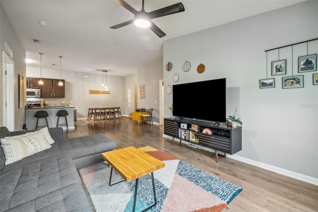 living room with light hardwood / wood-style floors and ceiling fan