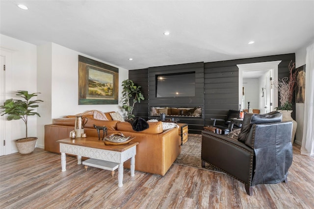 living room with wood-type flooring and a large fireplace