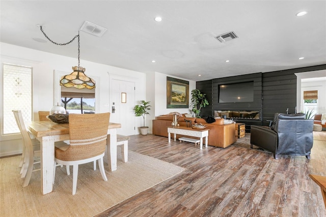 dining space featuring a large fireplace, hardwood / wood-style flooring, and a wealth of natural light