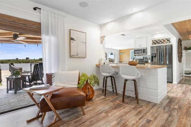 living area with ceiling fan and light hardwood / wood-style floors