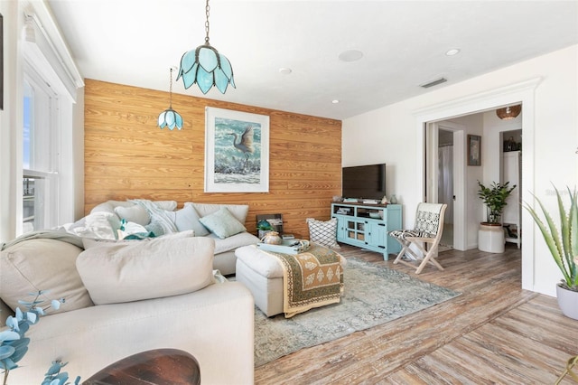 living room featuring hardwood / wood-style floors and wood walls