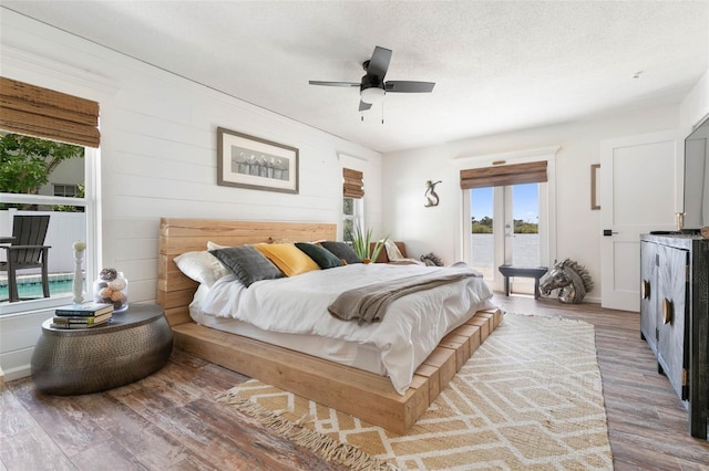 bedroom with hardwood / wood-style flooring, french doors, ceiling fan, and access to exterior