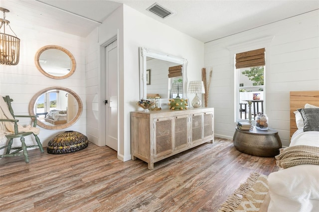 interior space with wood walls, hardwood / wood-style flooring, and a chandelier