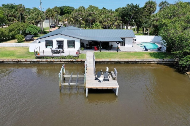 view of dock featuring a patio, a water view, and a lawn