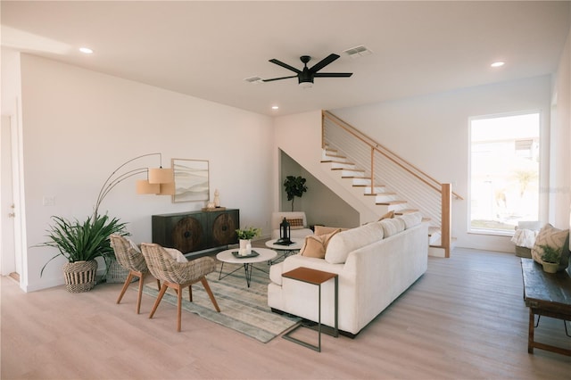 living room with light wood-type flooring and ceiling fan