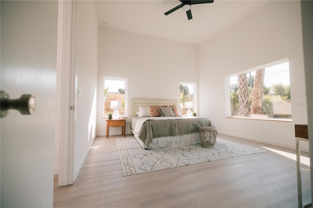 bedroom featuring high vaulted ceiling, light hardwood / wood-style flooring, and ceiling fan