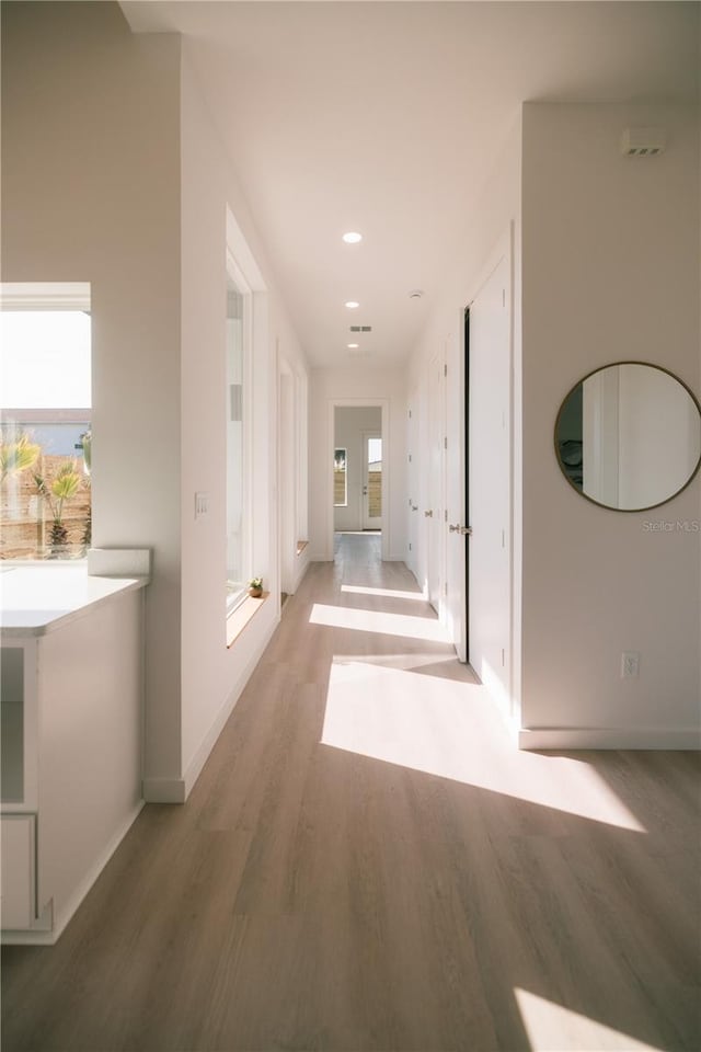 corridor with hardwood / wood-style flooring