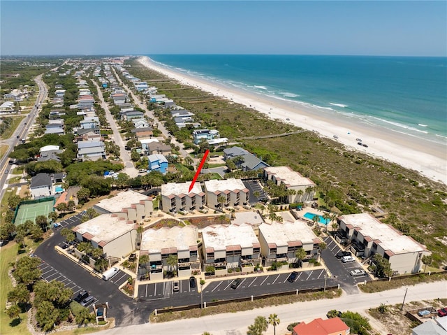 birds eye view of property with a water view and a beach view