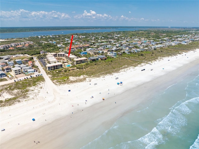 birds eye view of property with a water view and a beach view