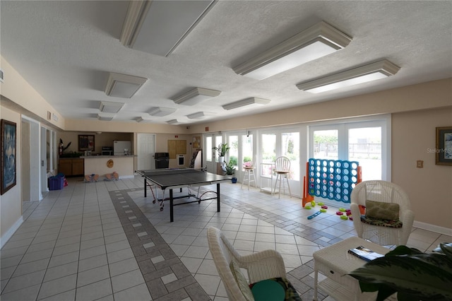 recreation room featuring light tile patterned floors and a textured ceiling