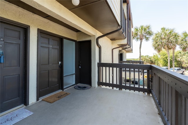 view of exterior entry with a balcony