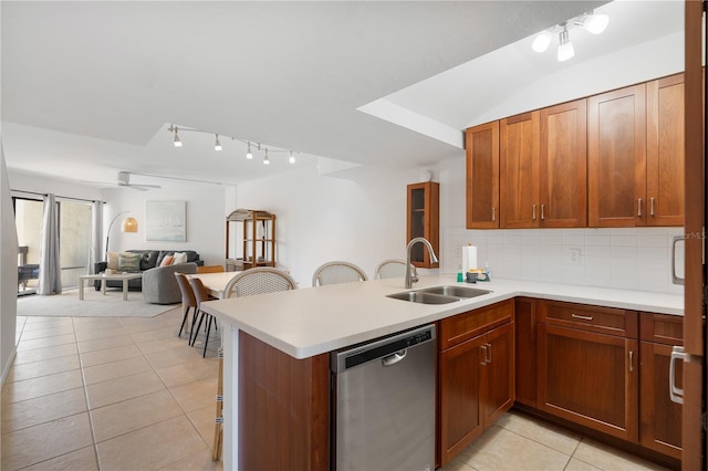 kitchen featuring sink, kitchen peninsula, decorative backsplash, and dishwasher