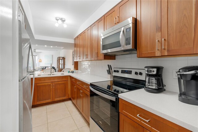 kitchen with decorative backsplash, appliances with stainless steel finishes, light tile patterned floors, and sink