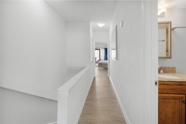 hallway with sink and light wood-type flooring