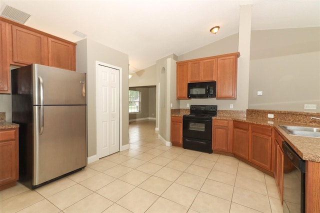 kitchen featuring light tile floors, sink, black appliances, vaulted ceiling, and stone counters