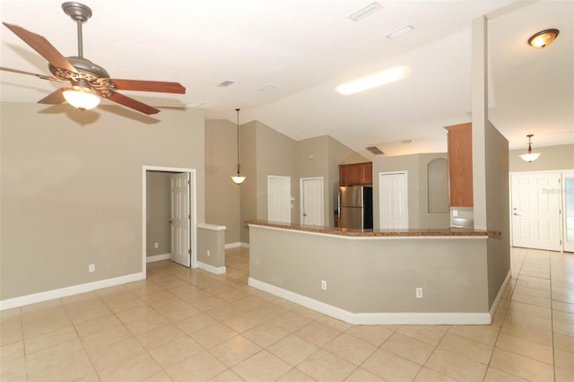 kitchen with decorative light fixtures, stainless steel fridge, light tile floors, and kitchen peninsula