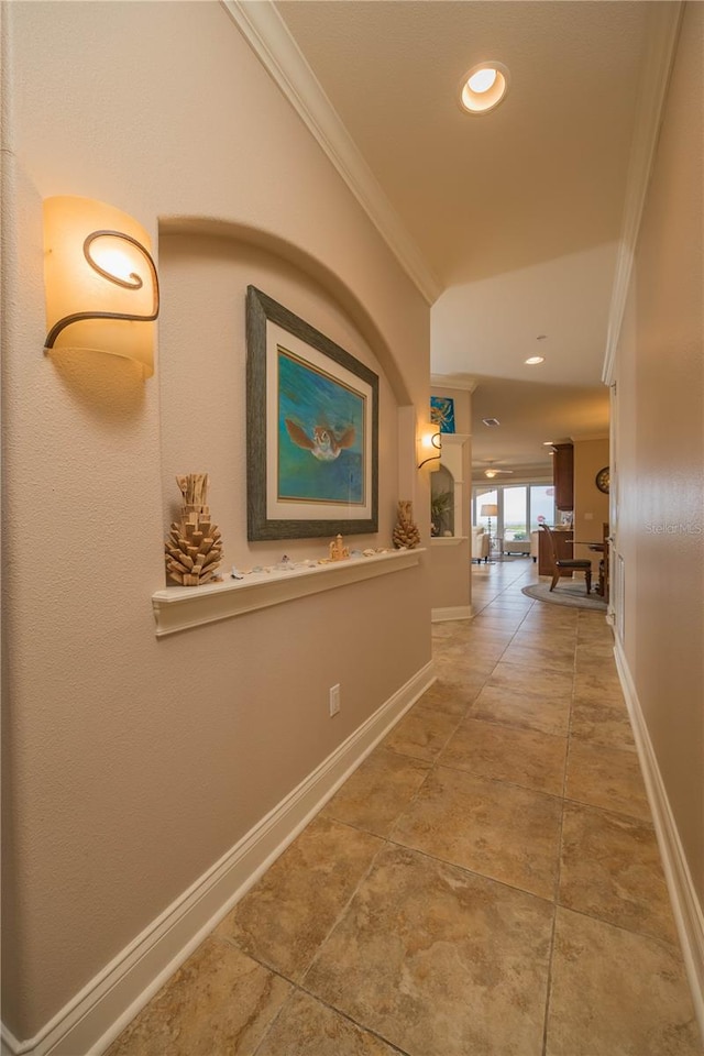 hall with tile floors and ornamental molding