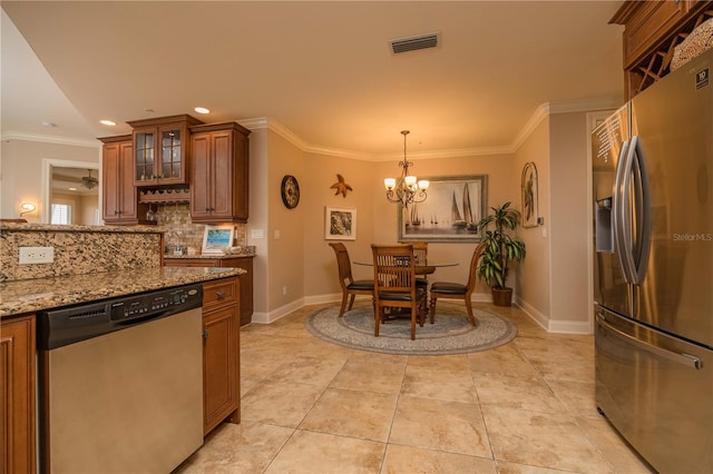 kitchen with backsplash, ceiling fan with notable chandelier, stainless steel appliances, and ornamental molding