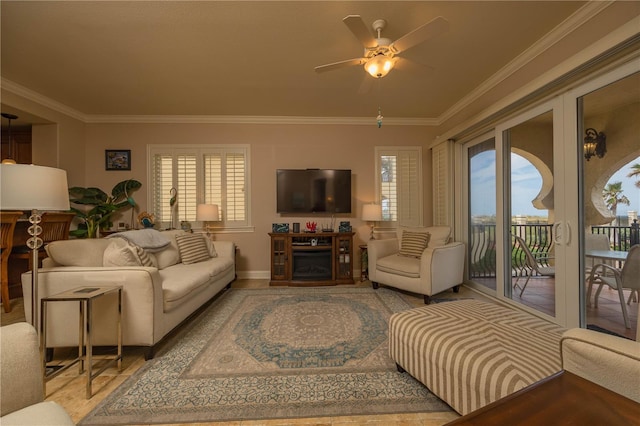 living room featuring a wealth of natural light, crown molding, and ceiling fan