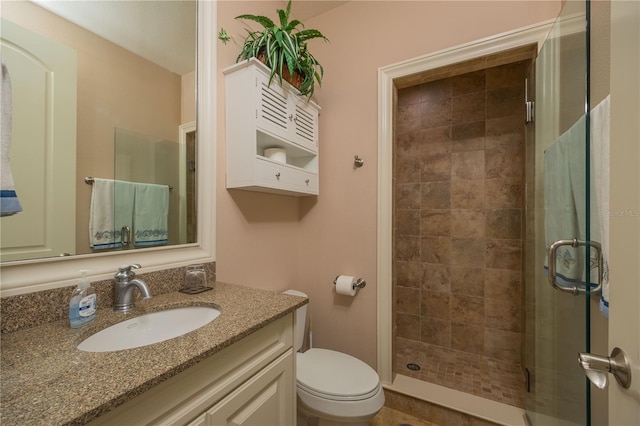 bathroom with oversized vanity, toilet, and a tile shower