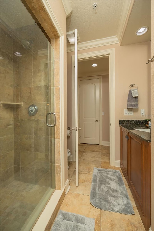 bathroom with tile flooring, toilet, a shower with shower door, ornamental molding, and vanity