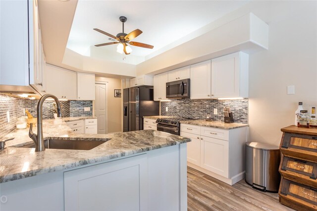 kitchen featuring light stone counters, white cabinets, ceiling fan, kitchen peninsula, and stainless steel appliances