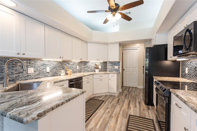 kitchen with ceiling fan, white cabinetry, appliances with stainless steel finishes, light wood-type flooring, and decorative backsplash