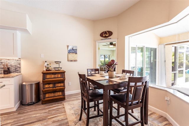 dining area featuring light wood-type flooring, ceiling fan, and a healthy amount of sunlight