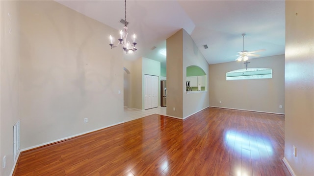 unfurnished living room with vaulted ceiling, light hardwood / wood-style flooring, and ceiling fan with notable chandelier