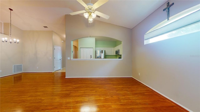 unfurnished living room featuring high vaulted ceiling, light hardwood / wood-style floors, and ceiling fan with notable chandelier