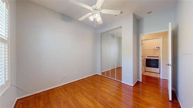 unfurnished bedroom with washer / dryer, a closet, hardwood / wood-style flooring, and ceiling fan