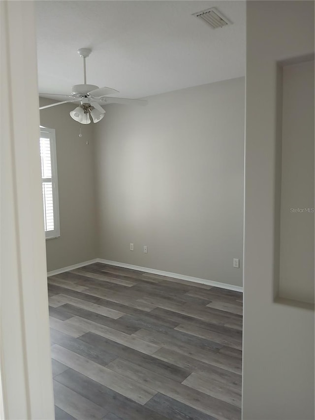 empty room featuring ceiling fan and dark wood-type flooring