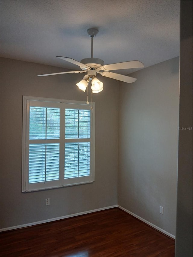 spare room with ceiling fan, dark hardwood / wood-style flooring, and a textured ceiling