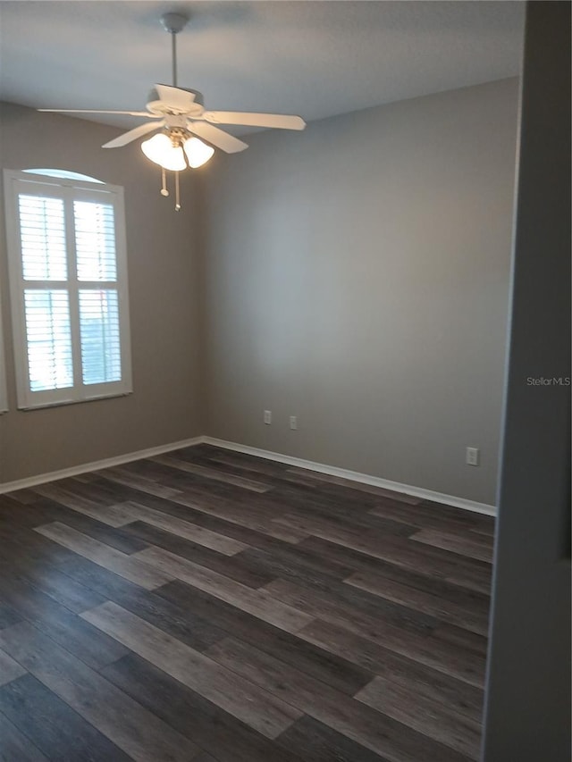 empty room with ceiling fan and dark wood-type flooring