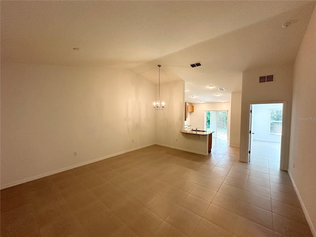 tiled spare room with a chandelier and lofted ceiling