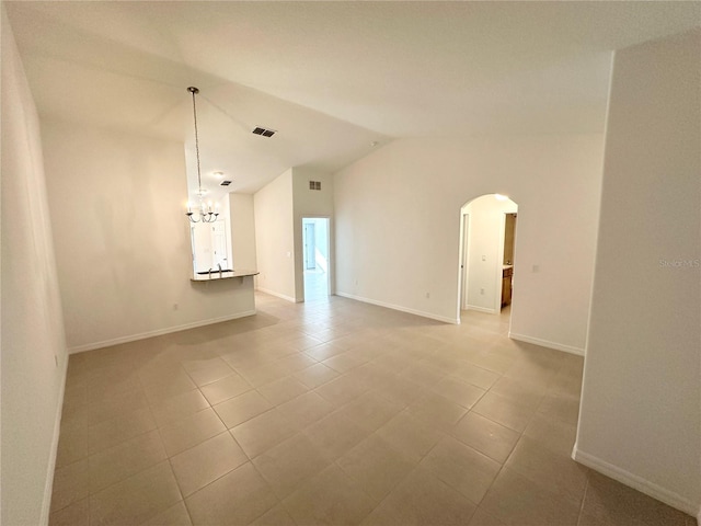 unfurnished room with vaulted ceiling, a notable chandelier, and tile flooring