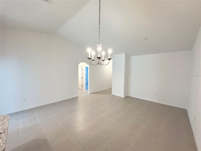 empty room with tile flooring, vaulted ceiling, and an inviting chandelier