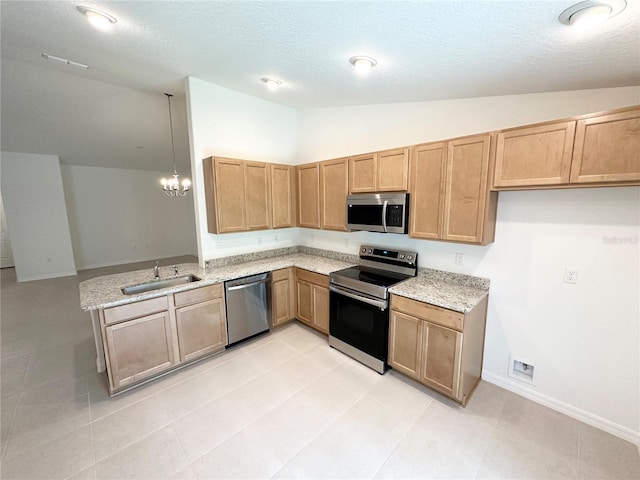 kitchen featuring appliances with stainless steel finishes, light tile floors, vaulted ceiling, and light stone counters