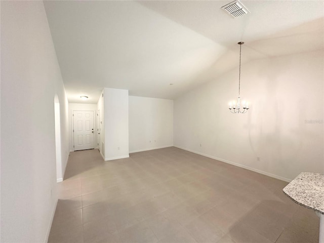 unfurnished room with lofted ceiling, light tile flooring, and an inviting chandelier