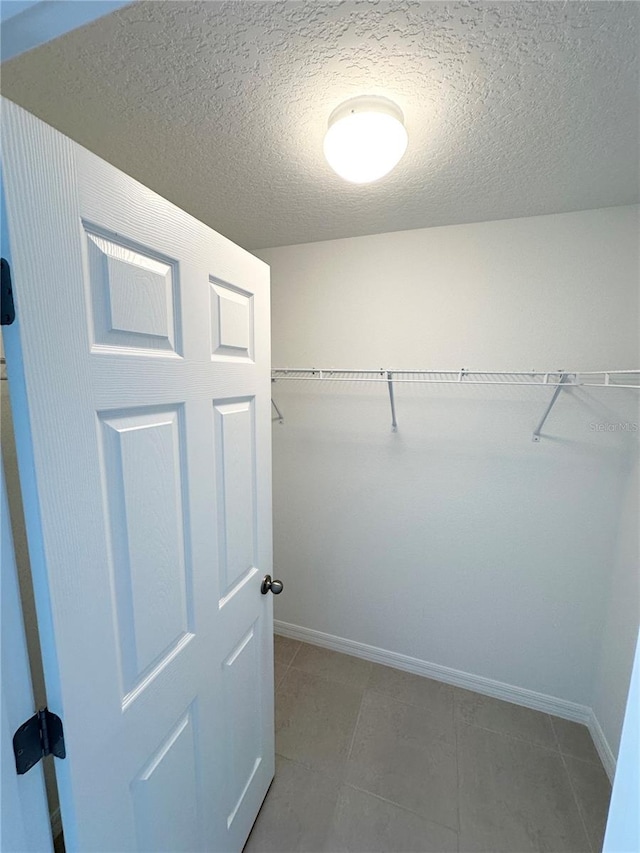 walk in closet with tile flooring